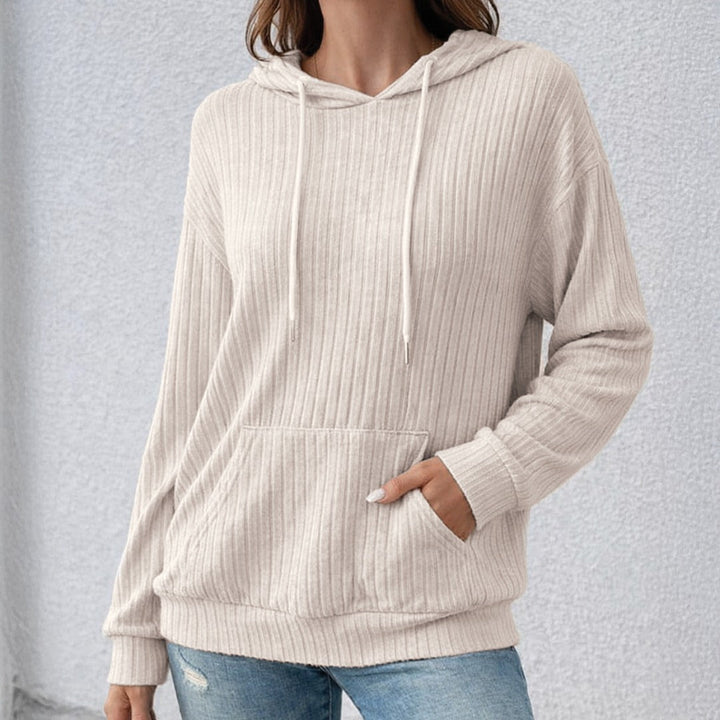 Woman wearing a beige textured hoodie, one hand in the kangaroo pocket | Grace Aura