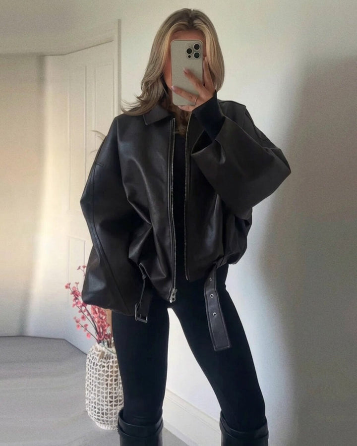 Black faux leather jacket worn with black leggings and knee boots