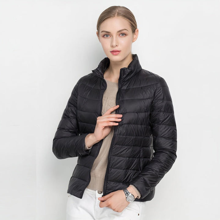 Black quilted puffer jacket with stand collar, worn by a woman | Grace Aura