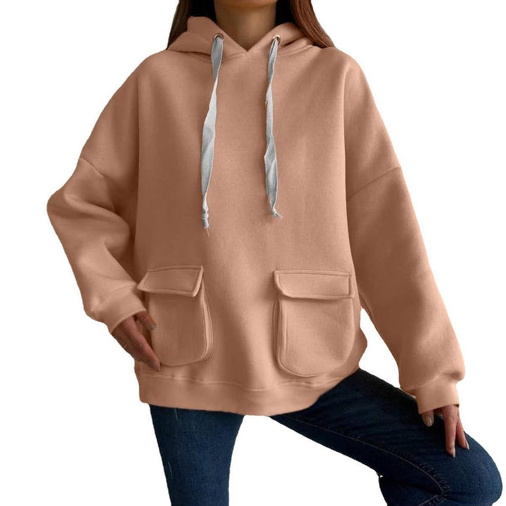 Woman wearing a peach oversized hoodie with flap pockets and dropped shoulders, on a white background | Grace Aura