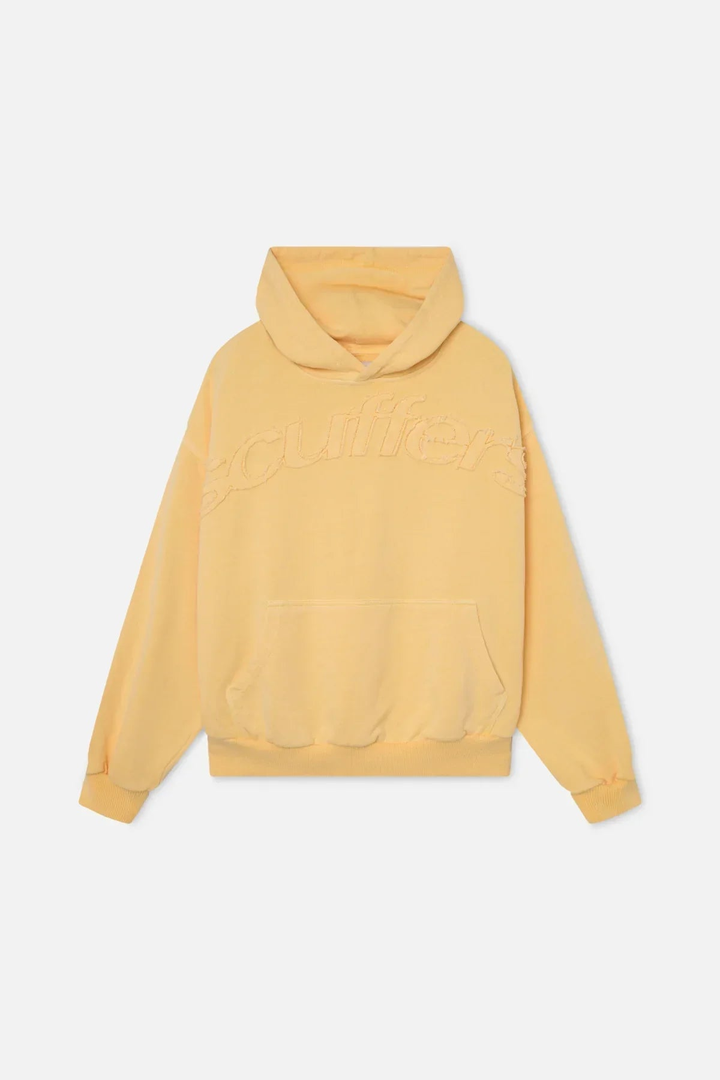 A pale yellow hoodie with a kangaroo pocket and a tonal raw edge appliqué wordmark across the chest, shown laid flat from the front on a white background.
