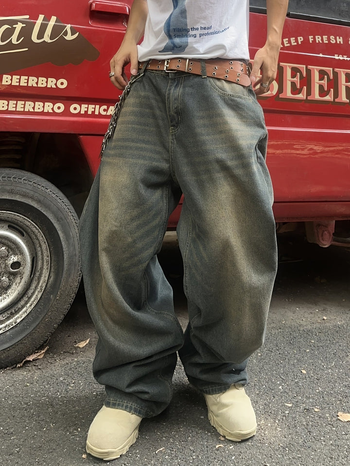Worn baggy washed denim jeans with chain, styled by person outdoors | Grace Aura