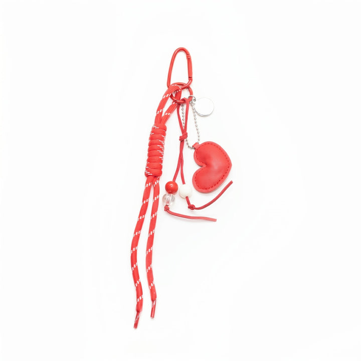 Red braided cord keychain with heart charm and beaded accents, flat lay | Grace Aura