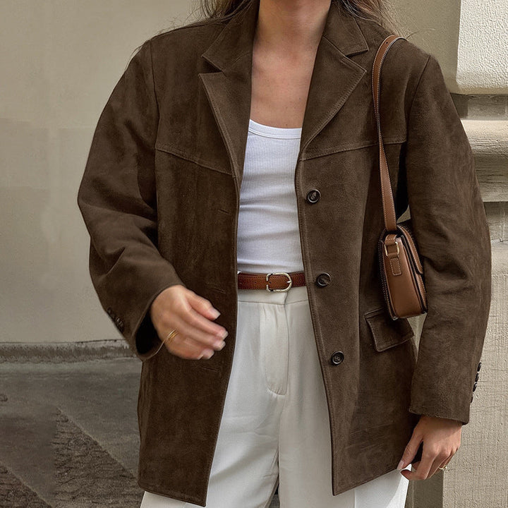 Woman wearing oversized brown suedette blazer jacket over white top outdoors | Grace Aura