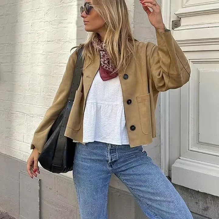 Woman wearing khaki single-breasted jacket with white top and denim jeans | Grace Aura