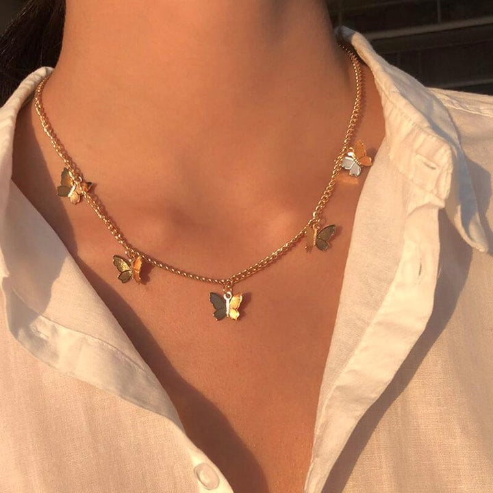 Gold chain necklace with butterfly charms worn by a woman | Grace Aura