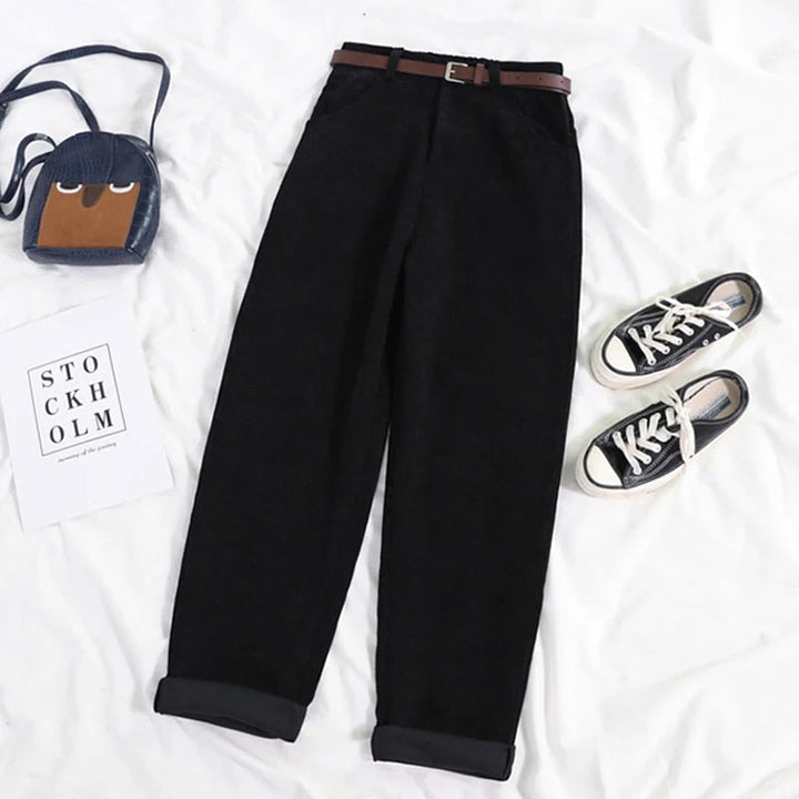 Black corduroy trousers with brown belt laid flat, styled with sneakers and bag | Grace Aura