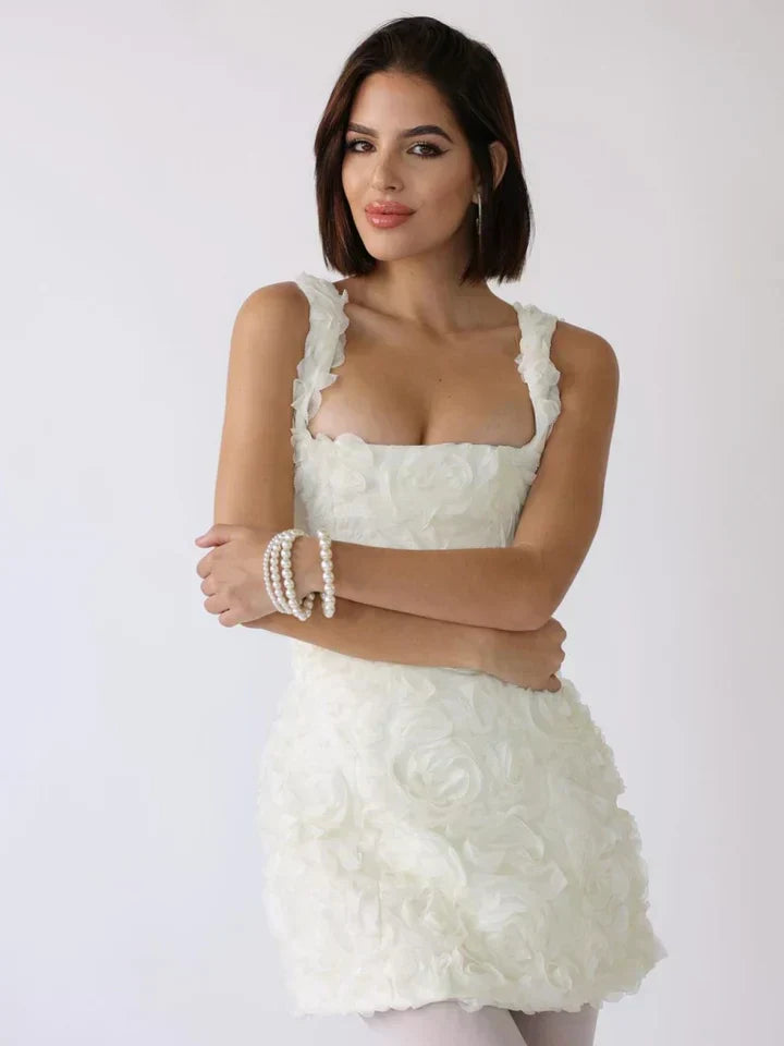 White floral rosette textured mini dress worn by woman, arms crossed | Grace Aura