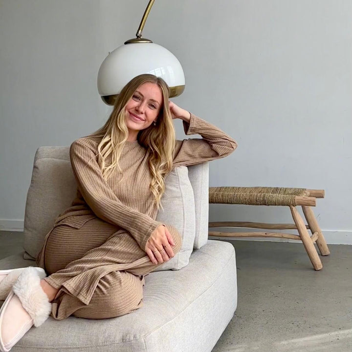 Woman wearing tan ribbed loungewear set, seated on beige couch, smiling | Grace Aura