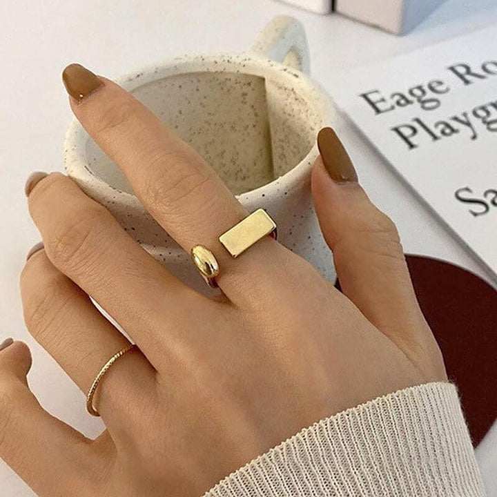 Gold flat bar and dome rings worn on hand near coffee cup | Grace Aura