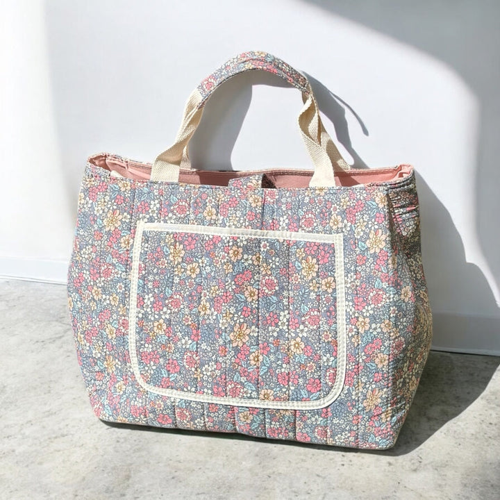 Quilted floral tote bag with front pocket, standing upright, canvas handles | Grace Aura
