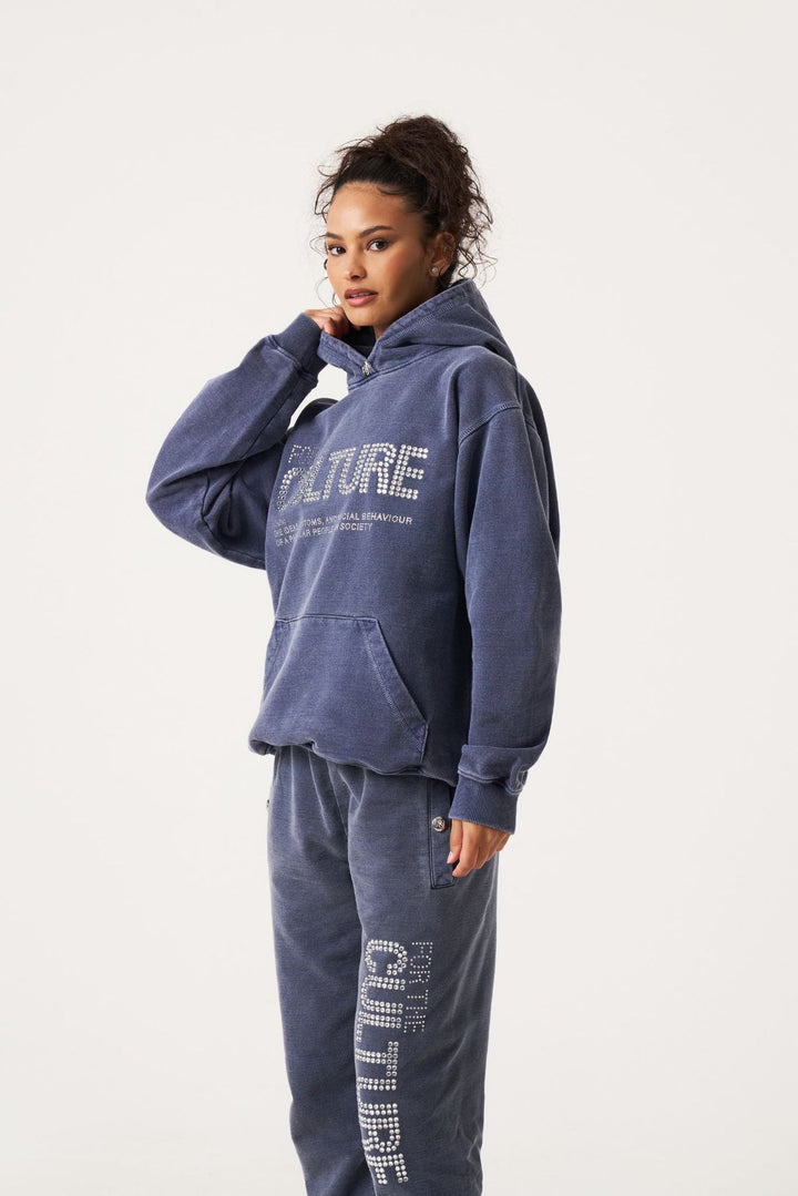 Woman wearing washed navy blue pullover hoodie with matching graphic joggers | Grace Aura