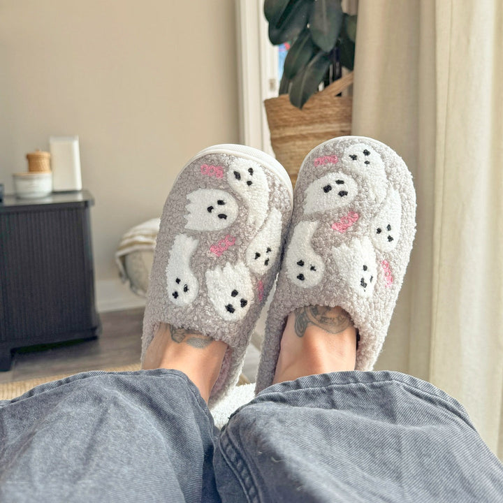 Gray plush slippers with white ghost print, worn on feet indoors | Grace Aura