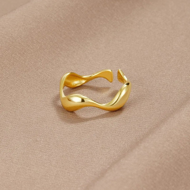 Gold wavy adjustable open ring on beige fabric surface | Grace Aura