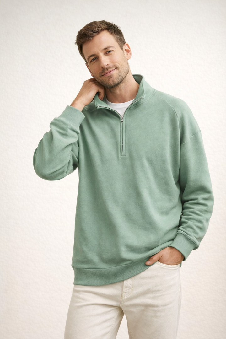 Man wearing sage green half-zip fleece sweater with white pants | Grace Aura