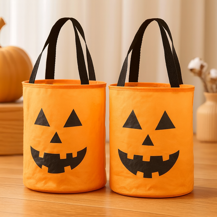 Two orange fabric pumpkin-shaped bags with black handles and faces | Grace Aura