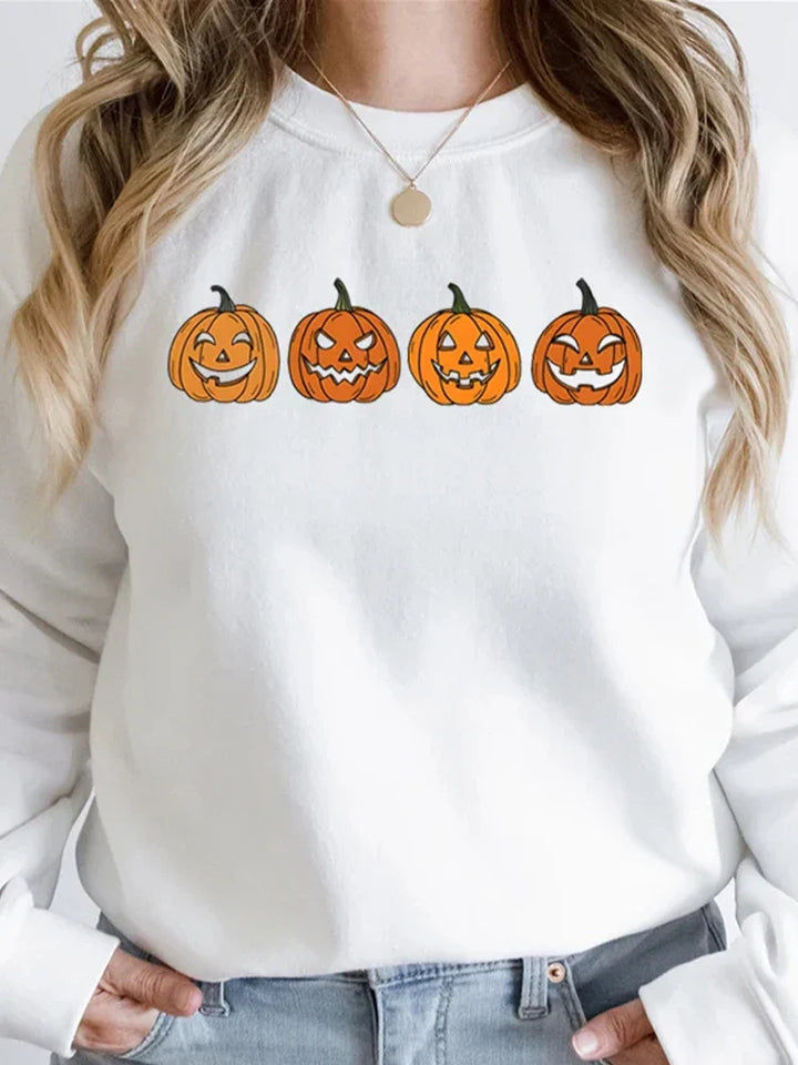 White sweatshirt with four jack-o-lantern pumpkin faces, worn by woman | Grace Aura