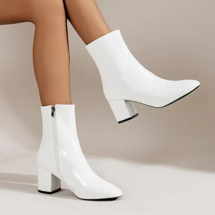 White patent leather ankle boots with block heel, worn on model&