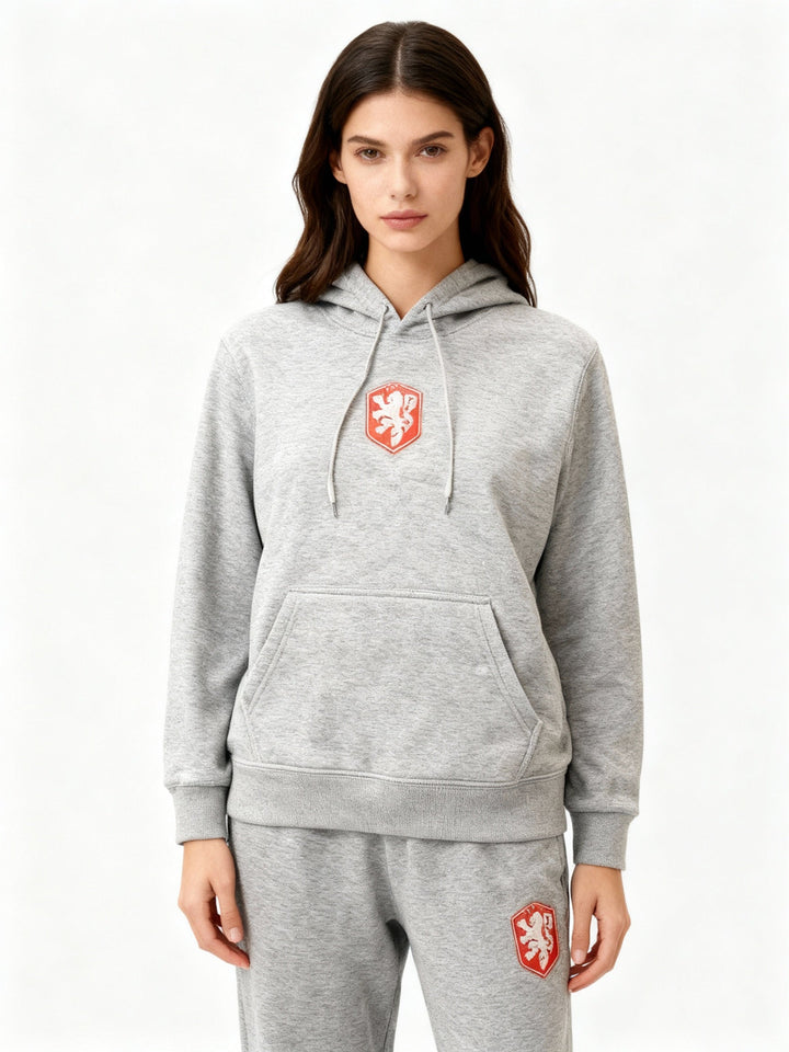 Woman wearing grey heathered hoodie with red crest and matching joggers | Grace Aura