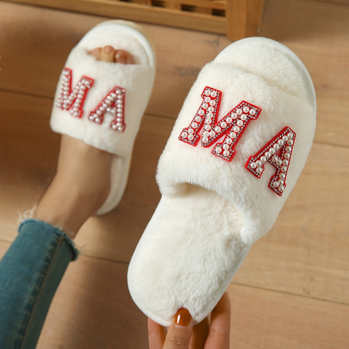 White fluffy open-toe slipper with pearl and rhinestone letters, held by hand | Grace Aura