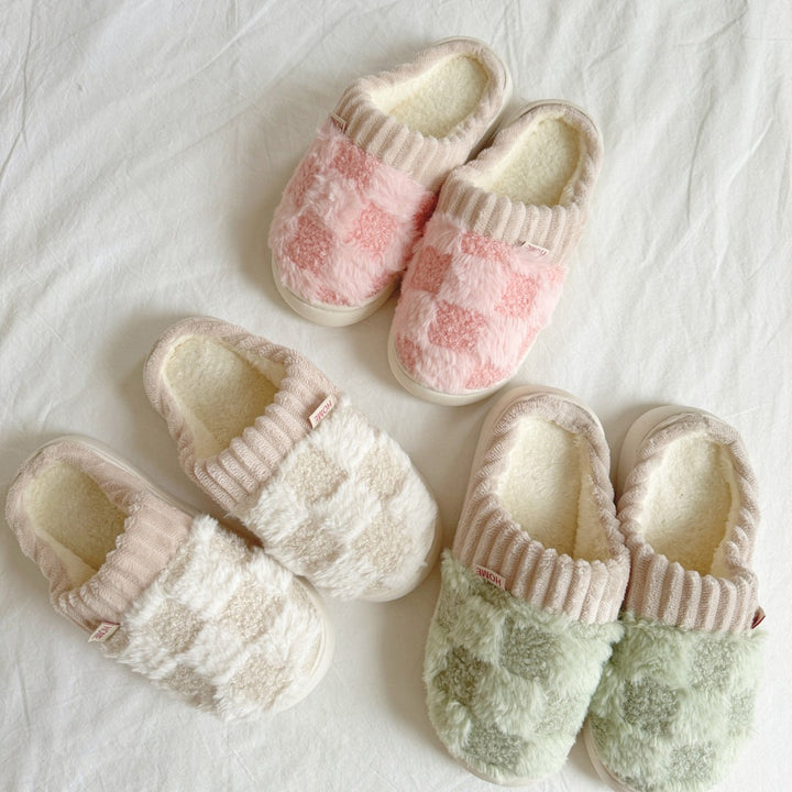 Three pairs fuzzy checkered slippers in pink, cream, and green, flat lay | Grace Aura