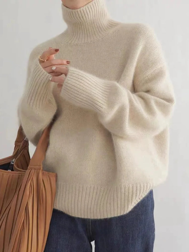 Cream turtleneck sweater worn by woman, oversized fit, paired with jeans | Grace Aura