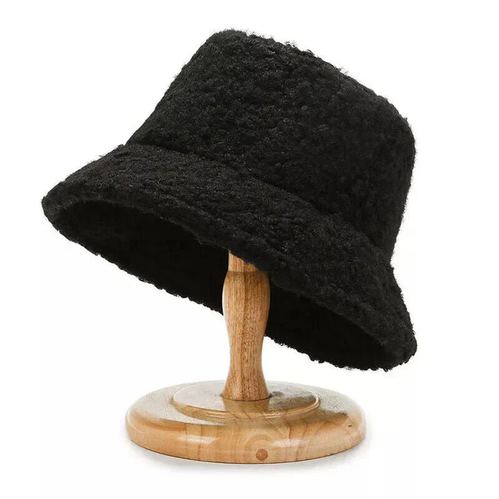Black fleece bucket hat displayed on wooden stand, textured teddy fabric | Grace Aura