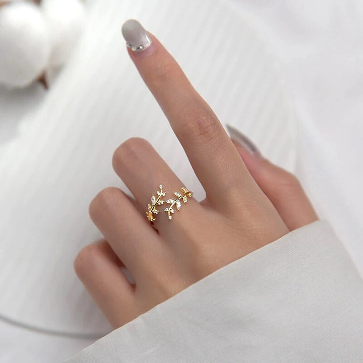 Gold leaf ring with cubic zirconia accents worn on finger | Grace Aura