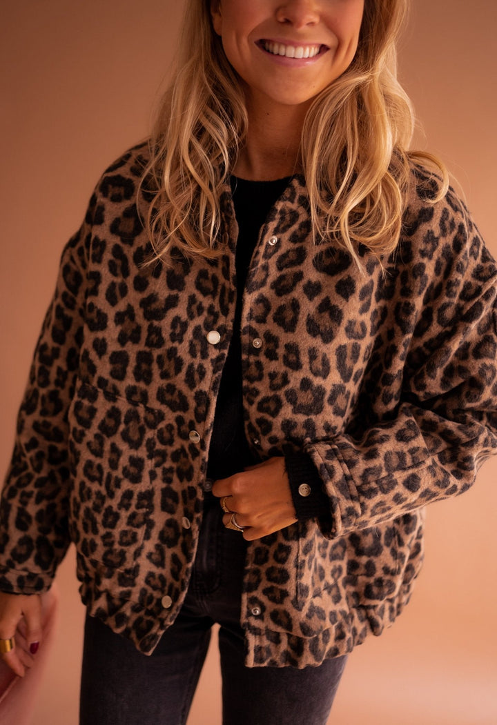 Brown leopard print button-up jacket worn by smiling woman with black jeans | Grace Aura