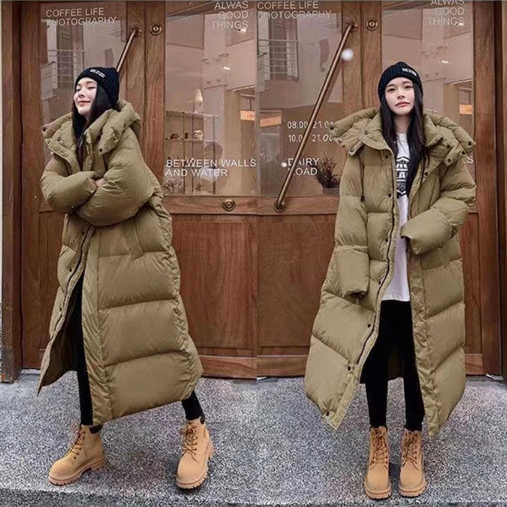 Woman wearing khaki long puffer jacket with hood, beanie and boots | Grace Aura