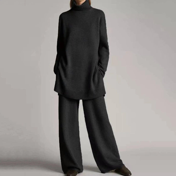 Woman wearing dark grey oversized turtleneck sweater with matching wide-leg knit pants | Grace Aura