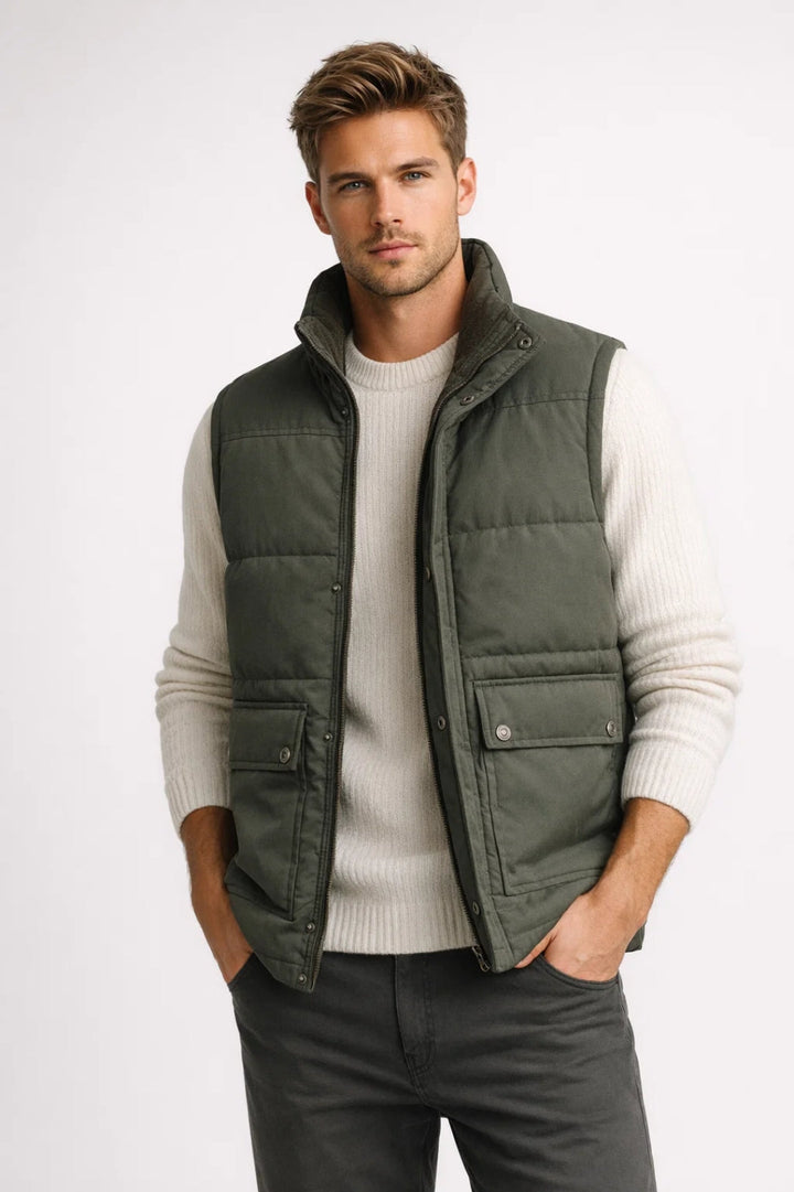 Man wearing olive green quilted vest over cream sweater with jeans | Grace Aura