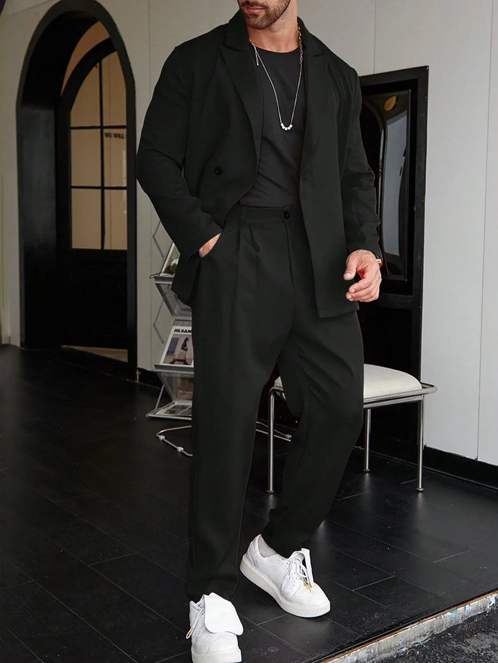Man wearing black relaxed-fit blazer and pleated trousers with white sneakers | Grace Aura