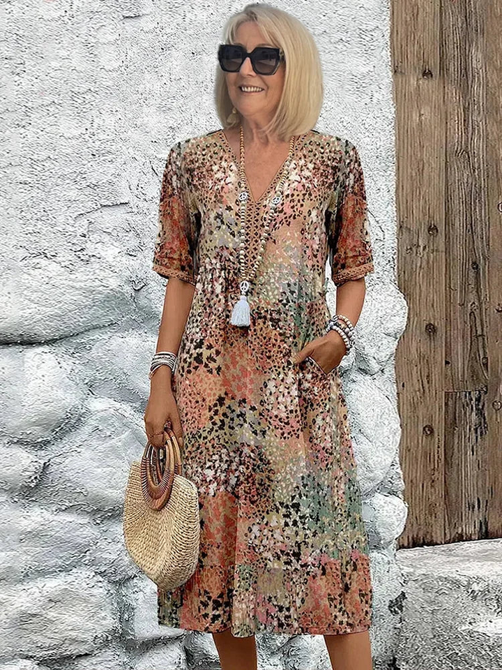 Woman wearing multicolor printed V-neck midi dress with round straw handbag | Grace Aura