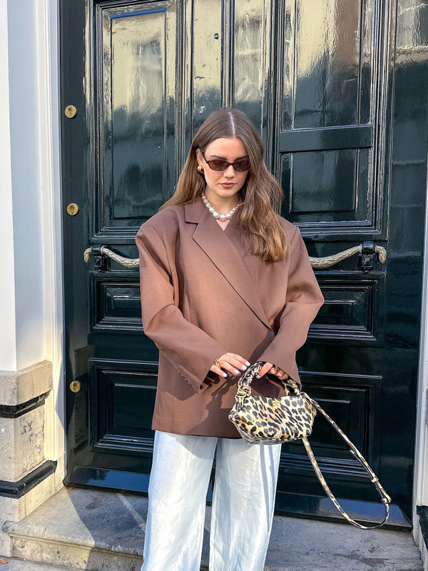 Woman wearing oversized brown blazer, sunglasses, holding leopard print handbag outdoors | Grace Aura