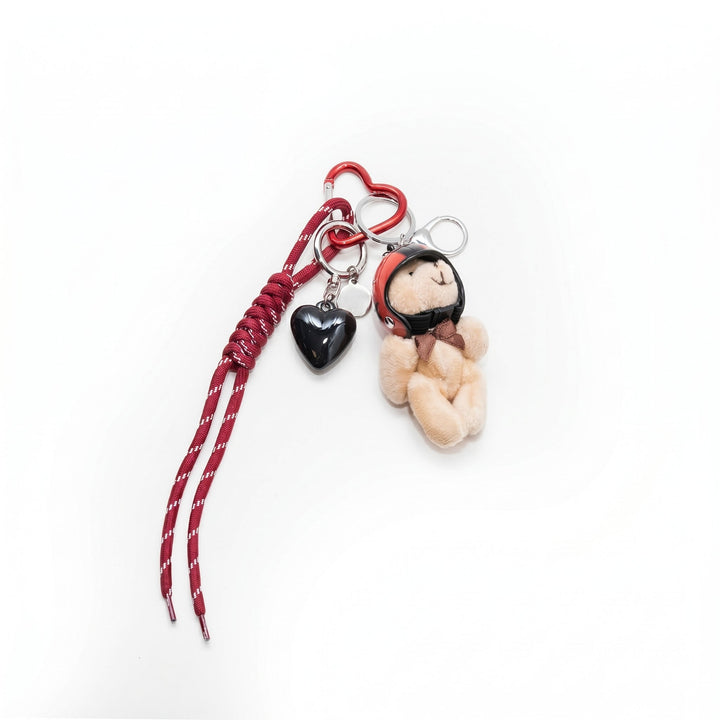 Red heart keychain with plush teddy bear charm, flat lay | Grace Aura
