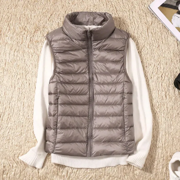 Taupe quilted puffer vest with white ribbed collar and sleeves, laid flat | Grace Aura