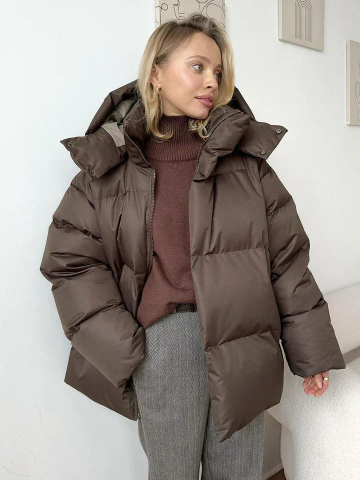 Woman wearing brown oversized puffer jacket with hood and turtleneck sweater | Grace Aura