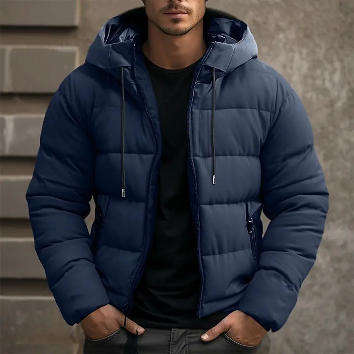 Navy blue quilted hooded puffer jacket worn by man with black shirt | Grace Aura