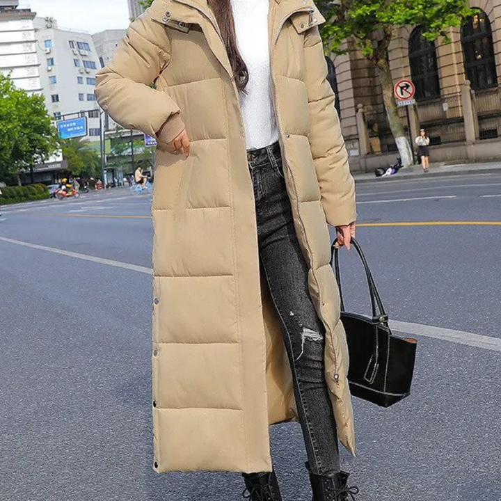 Beige long puffer coat worn by woman with distressed jeans outdoors | Grace Aura