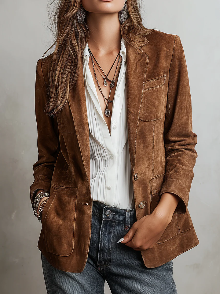 Woman wearing tan suede blazer over white blouse and layered necklaces | Grace Aura