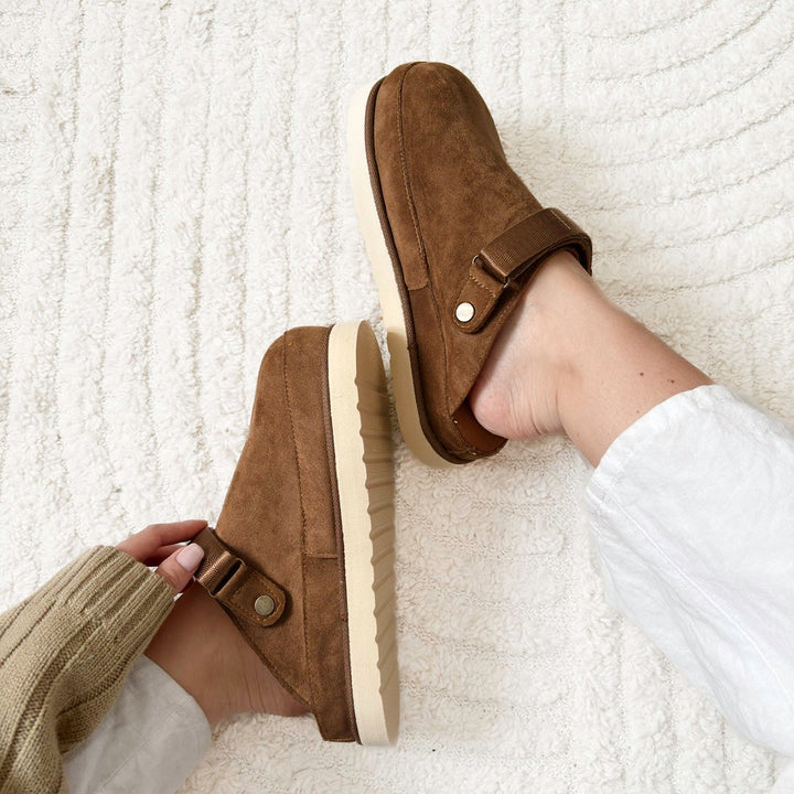 Brown suede platform clogs with strap, worn by person on rug | Grace Aura