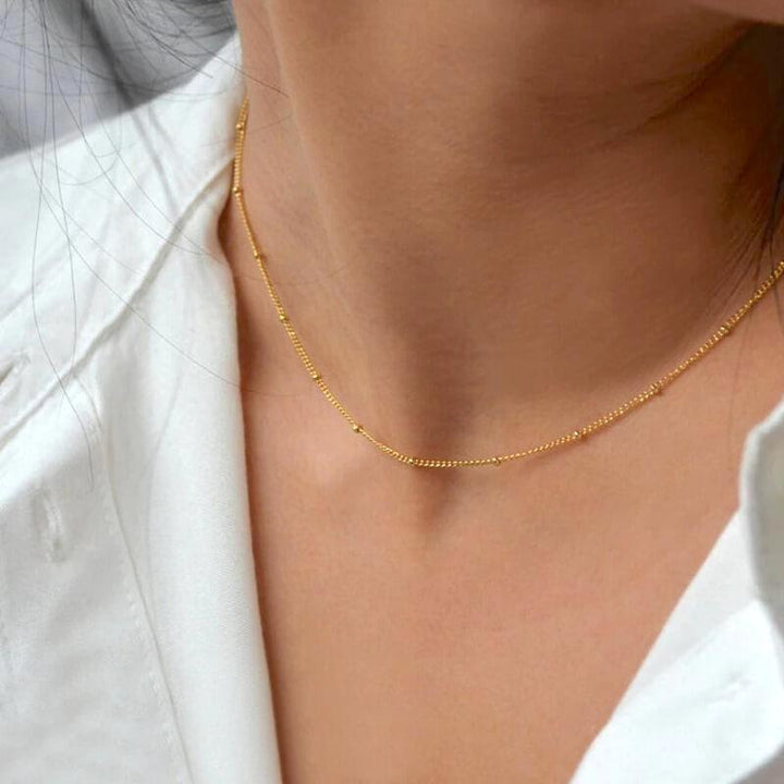 Gold beaded chain necklace worn on neck with white shirt | Grace Aura