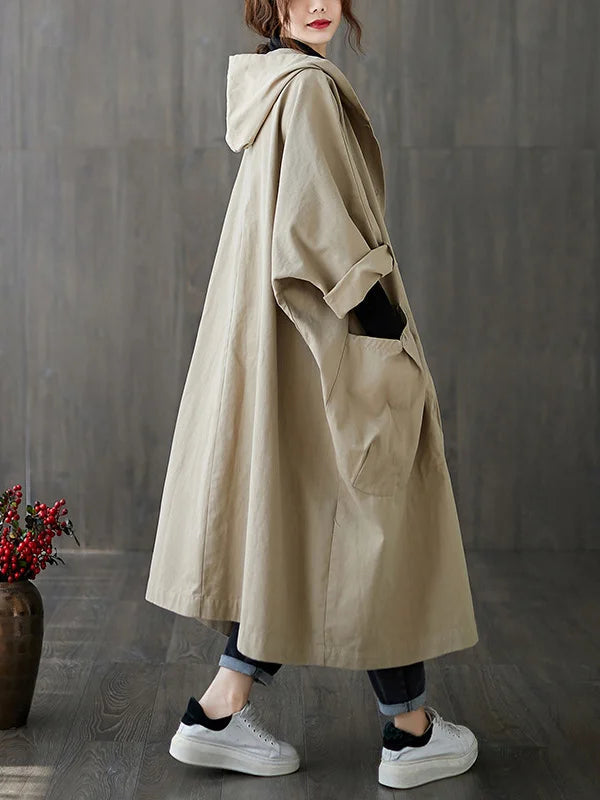 Beige hooded oversized trench coat worn by woman with jeans and sneakers | Grace Aura