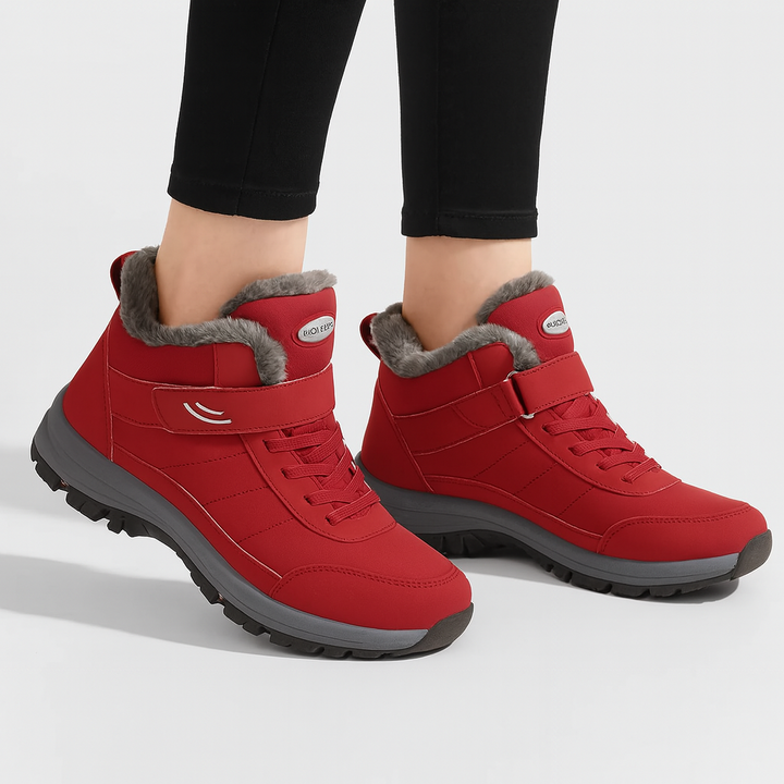 Red fur-lined winter boots with hook-and-loop strap worn by person | Grace Aura