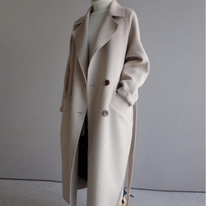 Beige oversized wool longline coat with belt, worn by standing model | Grace Aura