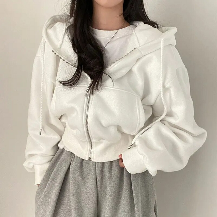 White zip-up oversized hoodie worn by woman with grey trousers | Grace Aura