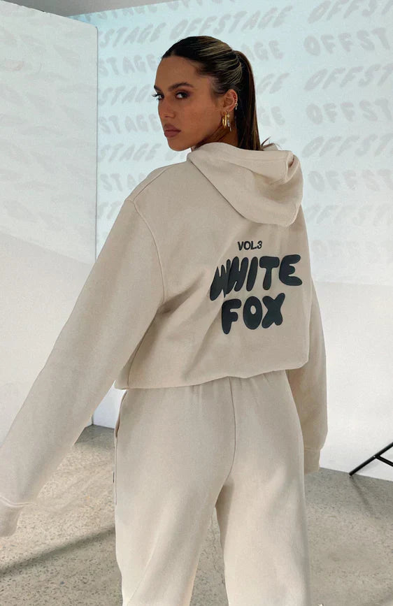 Woman wearing cream cropped hoodie and matching sweatpants, back view | Grace Aura