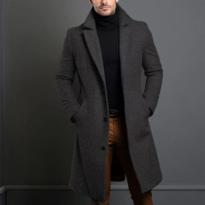 Man wearing dark gray wool trench coat over black turtleneck | Grace Aura