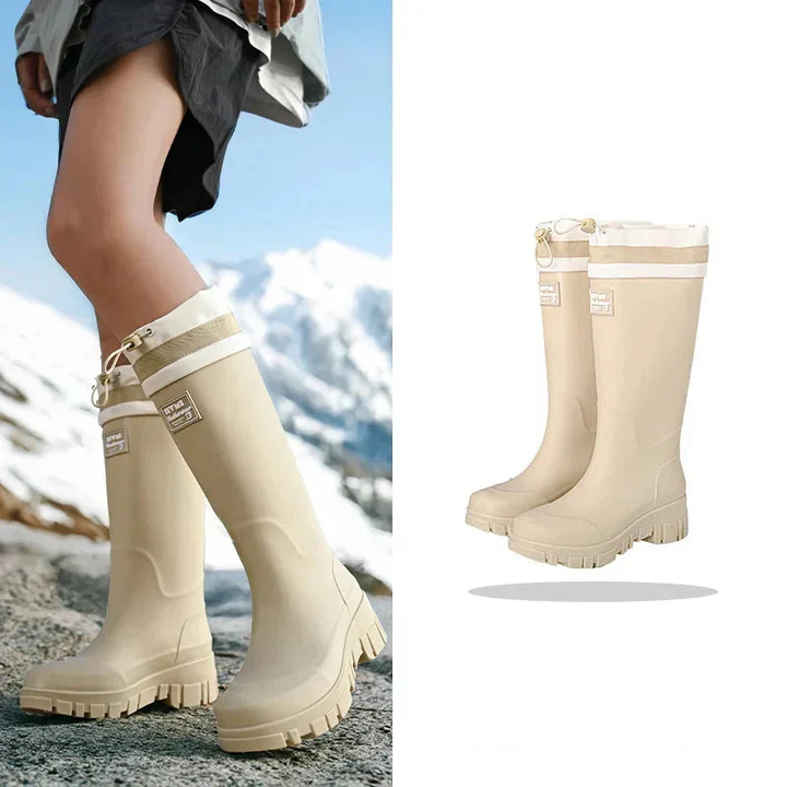Beige knee-high rubber boots, worn by model and shown standing alone | Grace Aura